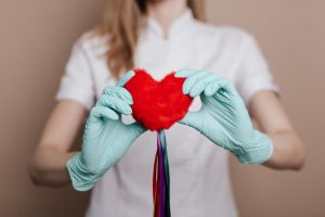 healthcare worker holds plush heart