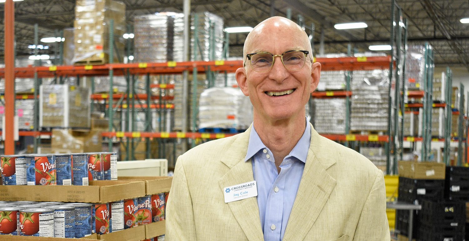 Jay Cole, Executive Director of CCS, standing in front of food pantry